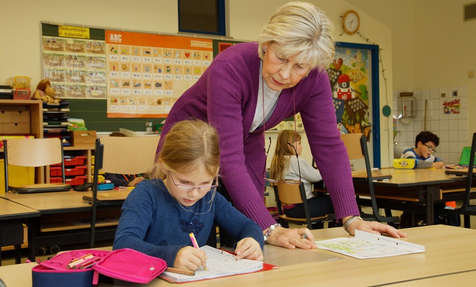 Lehrerin hilft Kind bei den Hausaufgaben